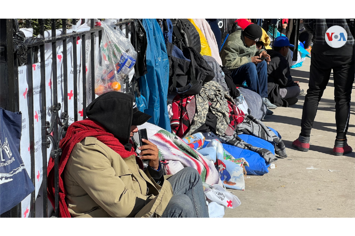 Los migrantes se refugian del frío con las prendas donadas. | Foto: Voz de América.