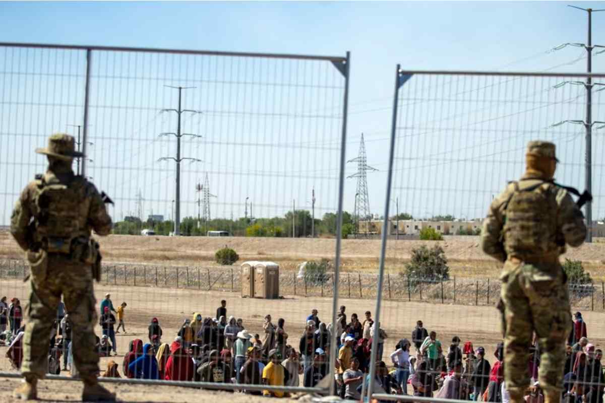 Una niña migrante de ocho años murió mientras estaba en un centro de detención de la CBP. En la foto, un grupo de migrantes espera frente a los agentes fronterizos en El Paso, Texas. | Foto: Voz de América.