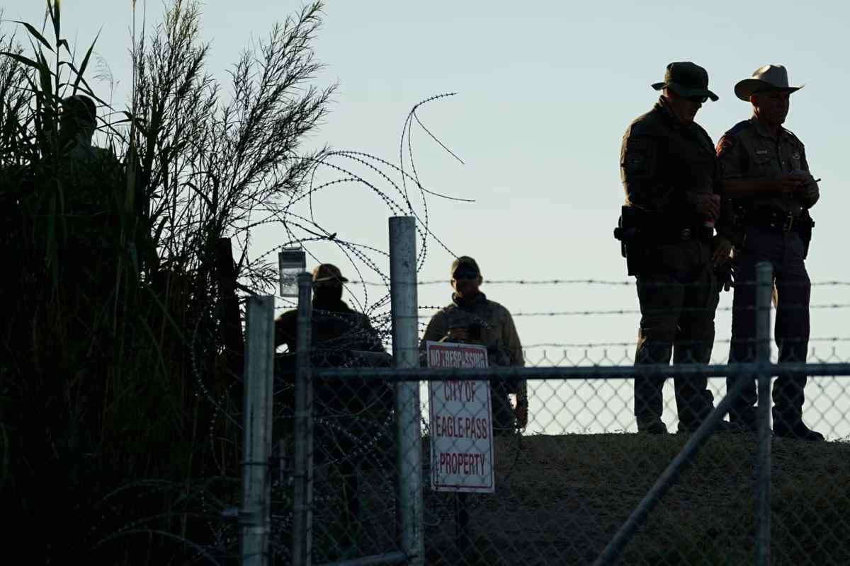 Policías de Texas se encuentran cerca de un cartel de "Prohibido el paso" y un alambre | Foto: Voz de América / AP